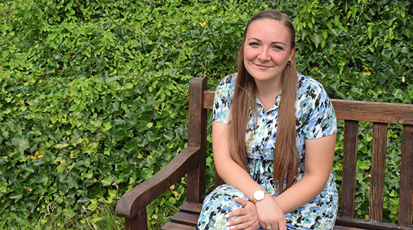 En kvinde sidder udenfor på en bænk